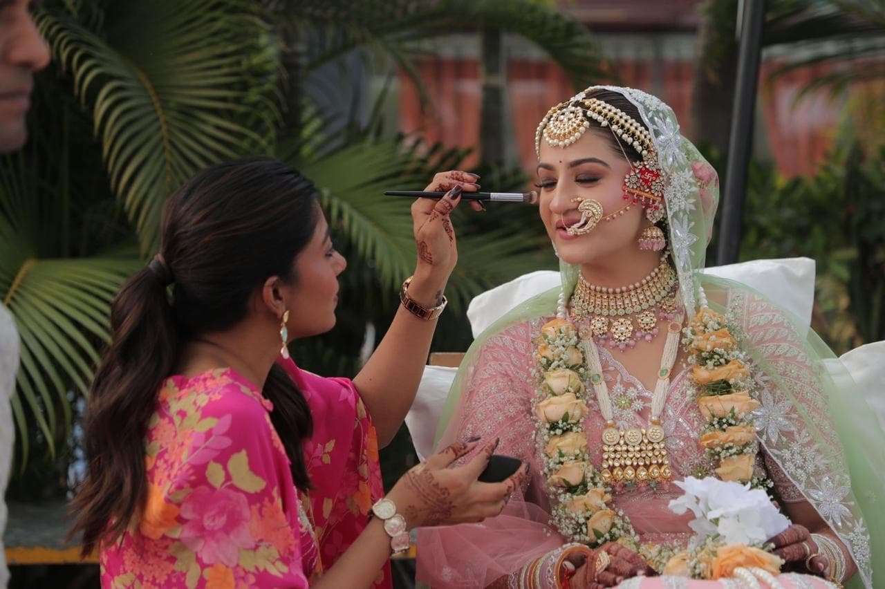 Sheetal applying bridal makeup outdoors